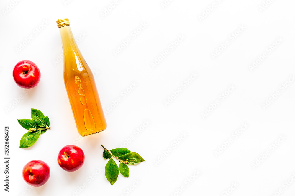 Top view of apple cider or vinegar - bottle with ripe fruits and leaves