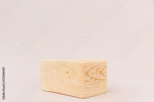 Wooden textured square podium on a light background. Background for product photography, organic cosmetics, eco products. Geometric shape for product presentation.