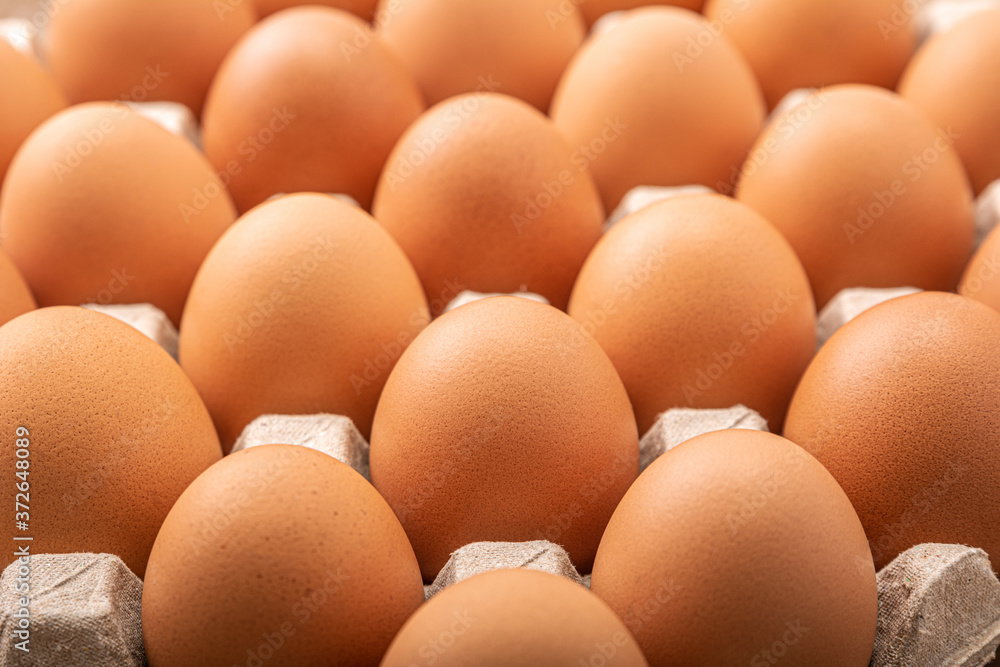 Many fresh raw brown chicken eggs in carton box. Many fresh raw brown chicken eggs in carton box.
