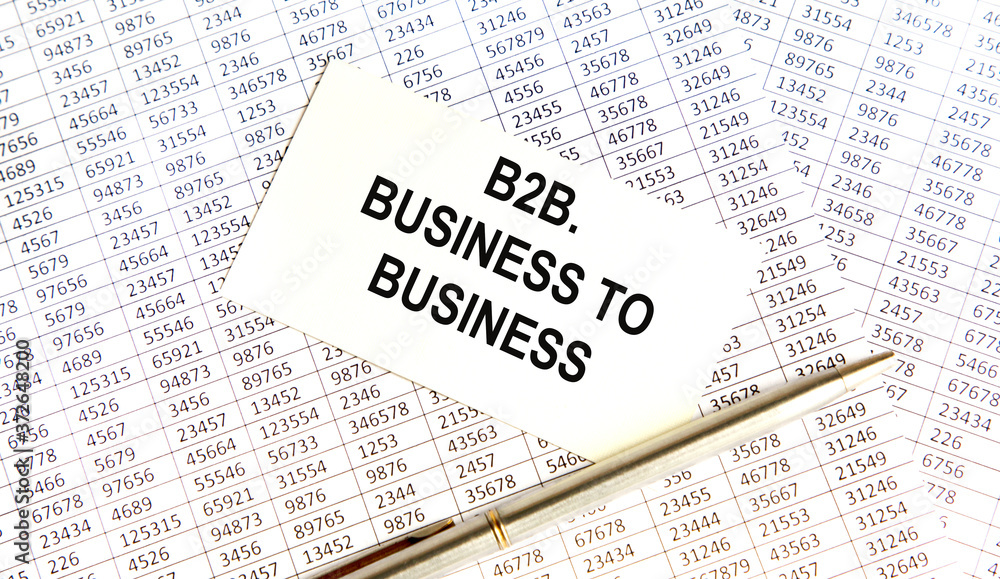 Obraz premium On the table are financial reports, a pen, a magnifying glass and a notebook with the inscription - B2B. Business to Business. Business and finance concept.