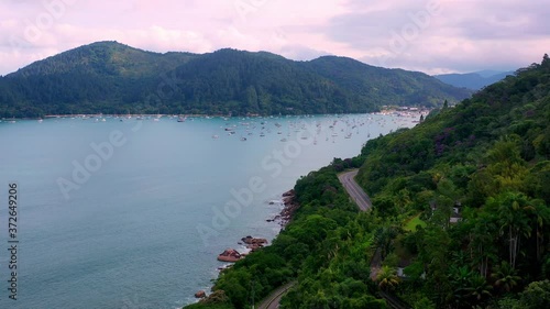 Aerial: drone shot in brazil santa rita beach  ubatuba with view to yacht park sailboats in ubatuba on the road that passes near the sea and the jungle during sunset sao paulo san pablo litoral north photo