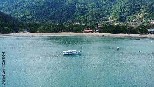 Aerial: drone shot in brazil santa rita beach  ubatuba with view to yacht park sailboats in on the road that passes the sea and the jungle sunset sao paulo san pablo litoral north escuna lancha photo