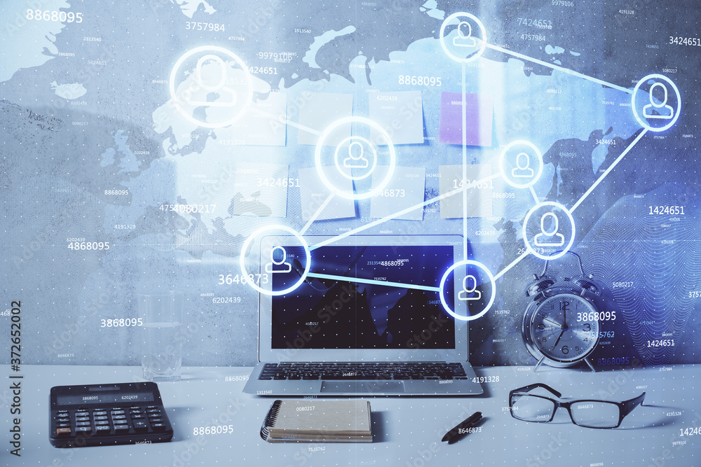 Computer on desktop with social network hologram. Double exposure. Concept of international people connections. Computer on desktop with social network hologram. Double exposure. Concept of international people connections.