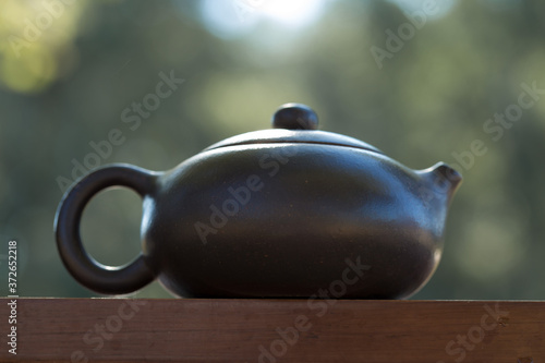 Chinese tea ceremony. Ceramic teapot made of clay and bowls on a wooden background.