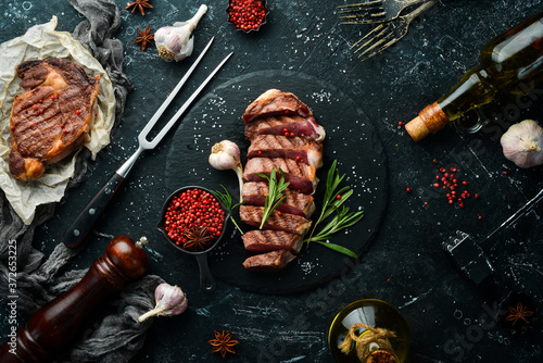 Wallpaper Mural Grilled sliced beef steak with rosemary and spices on a black stone background. Top view. Free space for your text. Torontodigital.ca