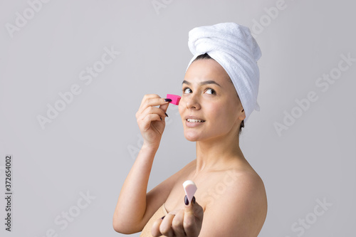 Beauty portrait of woman in white towel on head with a sponge for a body in view of a pink heart. Skincare cleansing eco organic cosmetic spa relax concept.