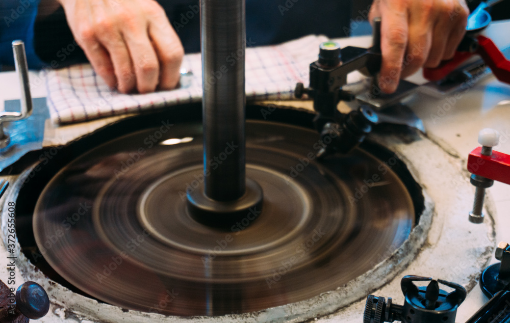 Amsterdam, Netherlands - July 2019: A skilled worker are shaping diamond they at the factory in Amsterdam, Netherlands. Amsterdam, Netherlands - July 2019: A skilled worker are shaping diamond they at the factory in Amsterdam, Netherlands.