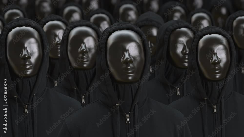 Unknown people wearing black masks and dark clothes raise their heads. Anonymosity, identity or equality concepts