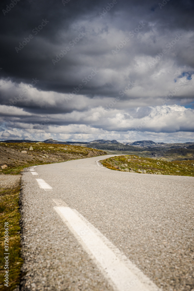 Empty road. road to clouds. rocky road goes into the distance into the blue sky.  Beautiful Norway landscape, Travel in Norway