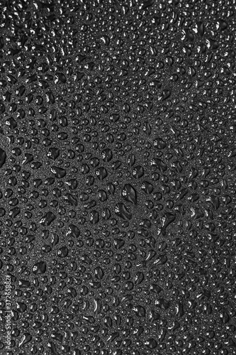 Water droplets on black background. Close-up photo of small water drops on black background.