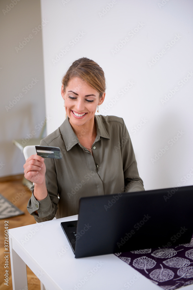 Woman happily spending her money on the internet Woman happily spending her money on the internet