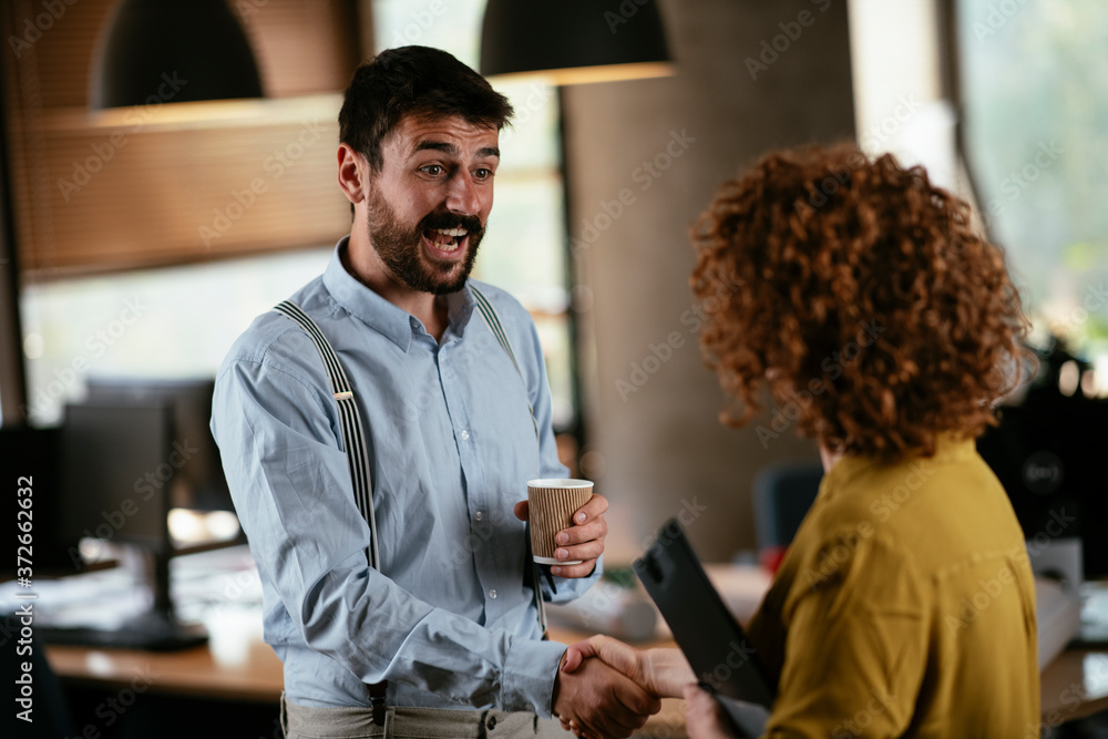 Colleagues in office. Businesswoman and businessman discussing work in office. Two friends in working together.