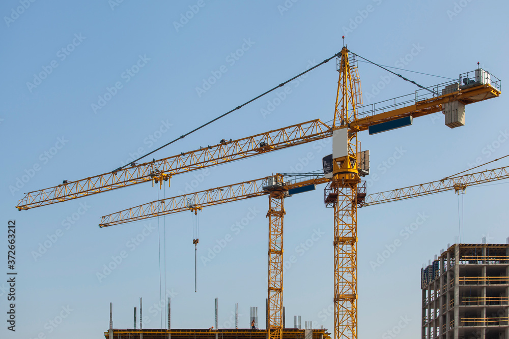 Construction site with cranes against the blue sky