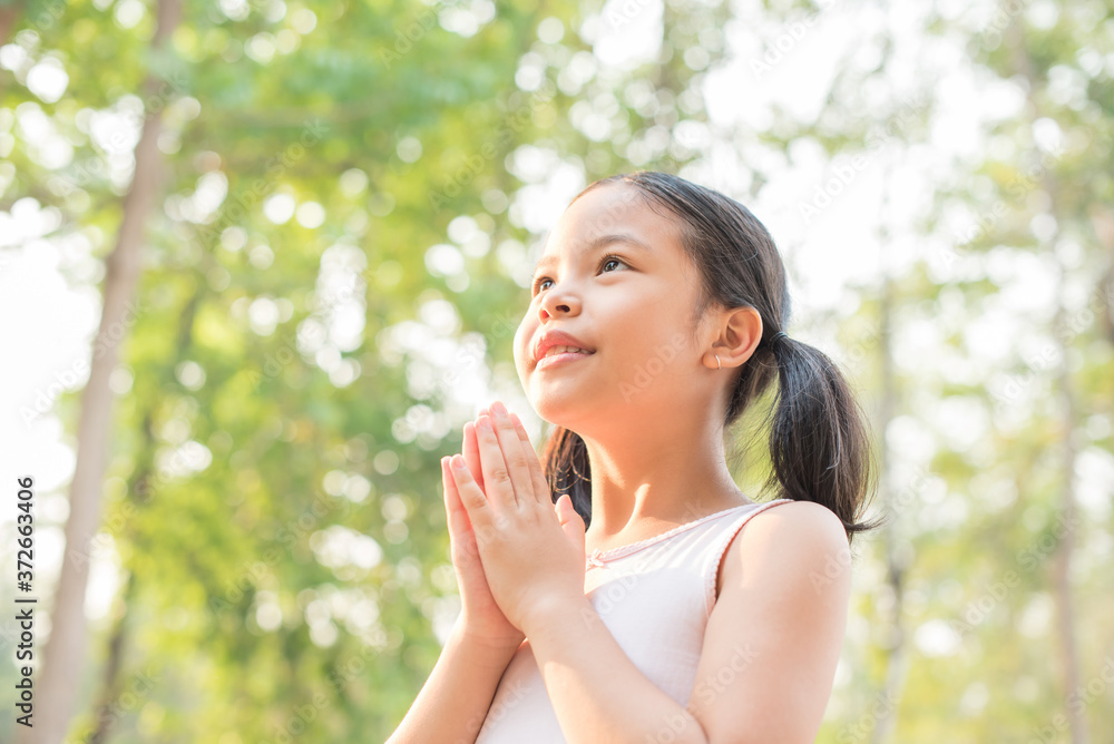 cute little girl hands praying to god with the bible in the morning on nature background. little asian girl hand praying for thank god. copy space. spirituality and religion faith hope concept. cute little girl hands praying to god with the bible in the morning on nature background. little asian girl hand praying for thank god. copy space. spirituality and religion faith hope concept.