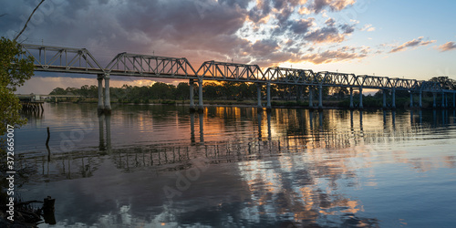 Sunset over a rail bridge crossing over the Burnett River, Bundaberg, Queensland