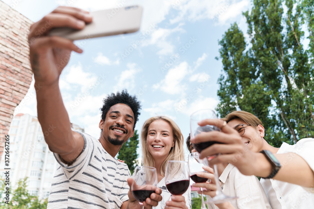 Obraz premium Happy group of friends with red wine