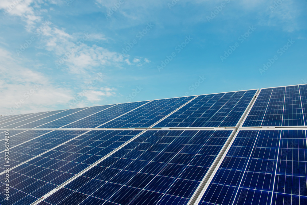 Photovoltaic power plant. Solar photovoltaic panels on blue sky background Photovoltaic power plant. Solar photovoltaic panels on blue sky background