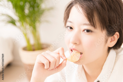 ポテトチップスを食べる女性