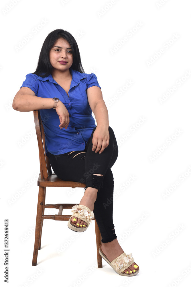 portrait of a latein woman sitting on a chair on white background, legs crossed portrait of a latein woman sitting on a chair on white background, legs crossed