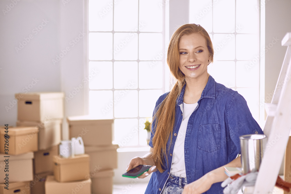 Beautiful young woman on a white wooden stepladder. Ready to repair the room. Women housework concept Beautiful young woman on a white wooden stepladder. Ready to repair the room. Women housework concept