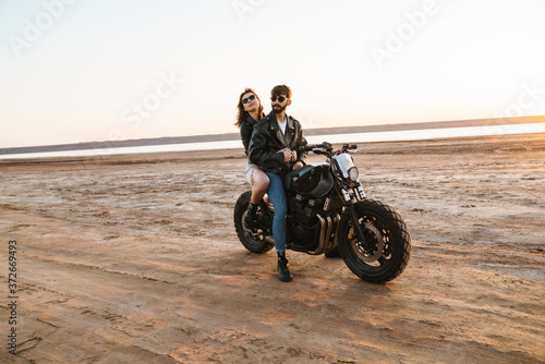 Beautiful young stylish couple enjoying ride on a motorbike