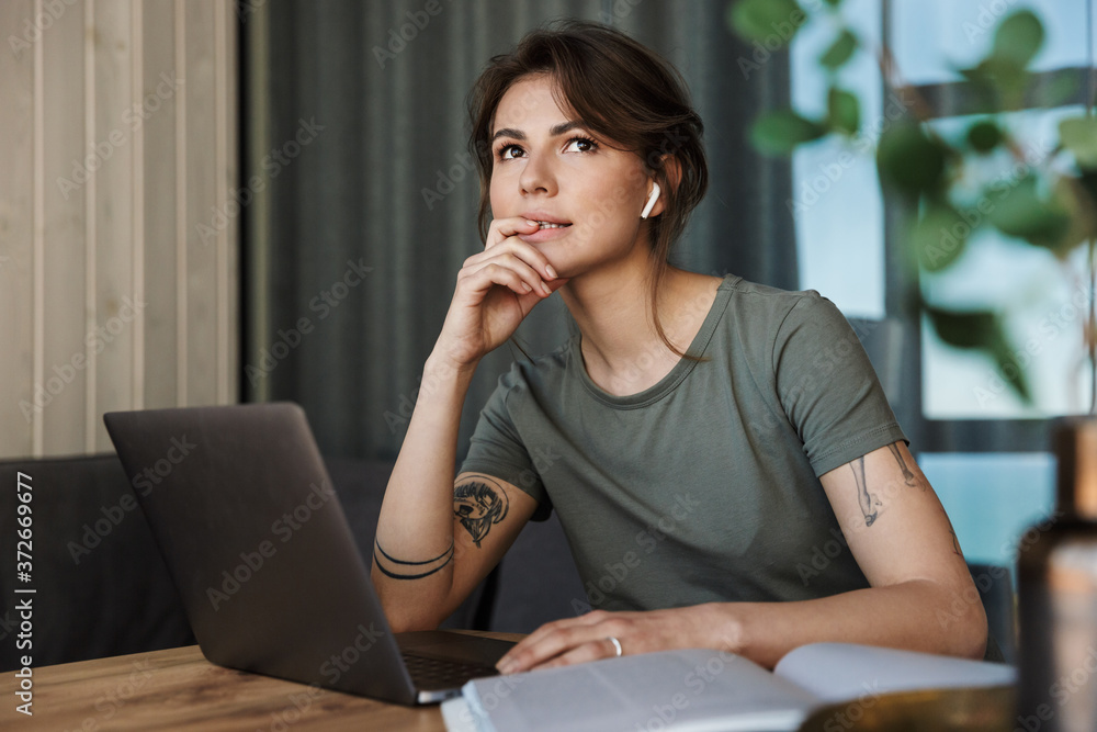 Attractive young woman working on laptop computer Attractive young woman working on laptop computer