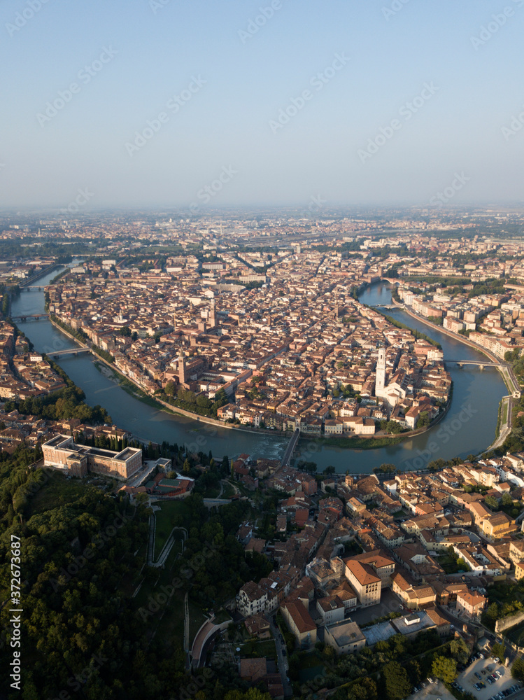 Aerial view of Arno river bend in Florence city, bridges over river, narrow streets, houses with tiled orange roofs, old town squares, italian architecture. Historic centre of Firenze Tuscany Italy