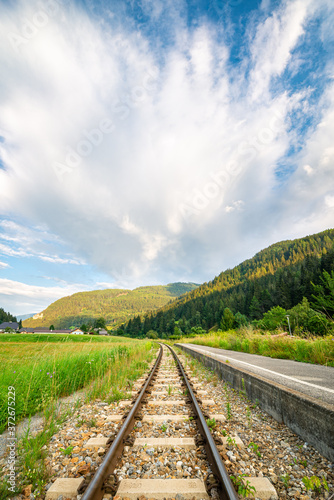 Railroad in the Alps with anvil of a stormcloud over the mountains