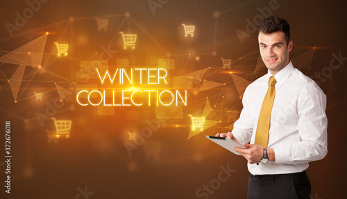 Businessman with shopping cart icons and WINTER COLLECTION inscription, online shopping concept