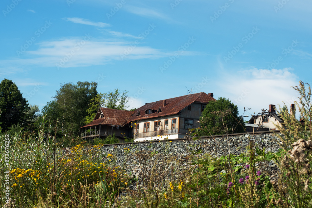Beautiful summer landscape of the countryside. A wooden house and a railway line. Beautiful summer landscape of the countryside. A wooden house and a railway line.
