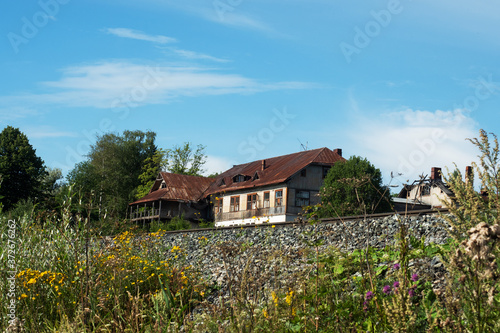 Beautiful summer landscape of the countryside. A wooden house and a railway line.