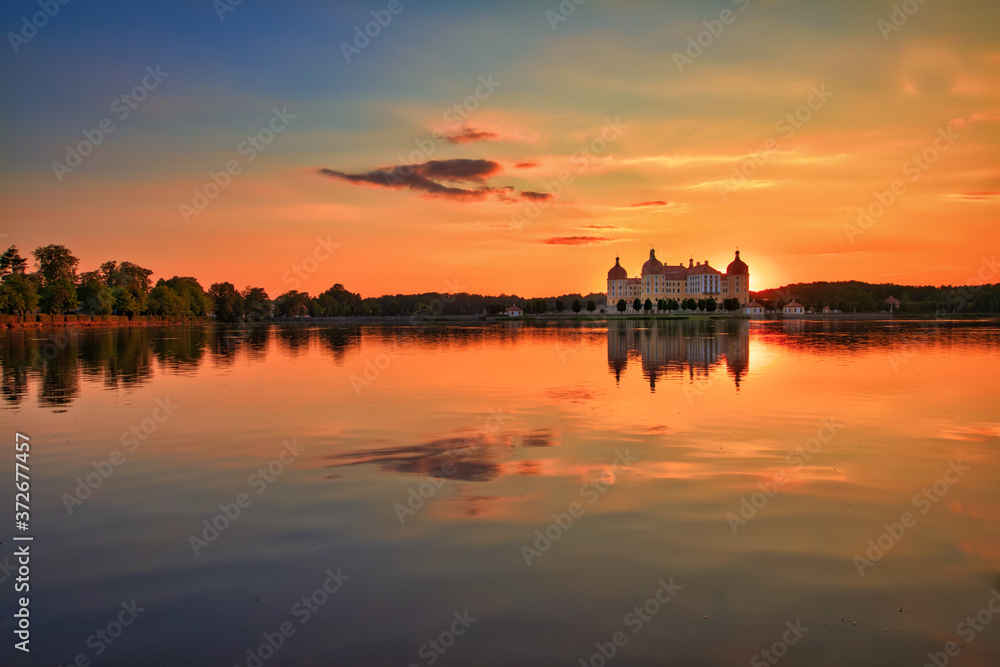 Beautiful evening panorama of Moritzburg Baroque palace surrounded by a lake.