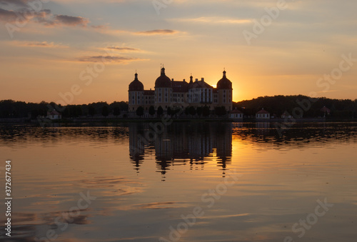 Beautiful evening panorama of Moritzburg Baroque palace surrounded by a lake.