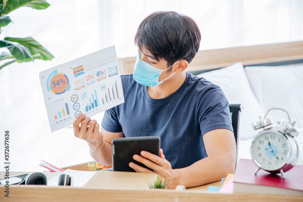 Young Asian man feels happy while video call Meeting by using tablet on Work For Home Period. COVID-19 Lock Down. Young Asian man feels happy while video call Meeting by using tablet on Work For Home Period. COVID-19 Lock Down.