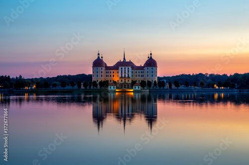 Beautiful evening panorama of Moritzburg Baroque palace surrounded by a lake.