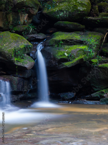 Water flowing between rocks with green moss.