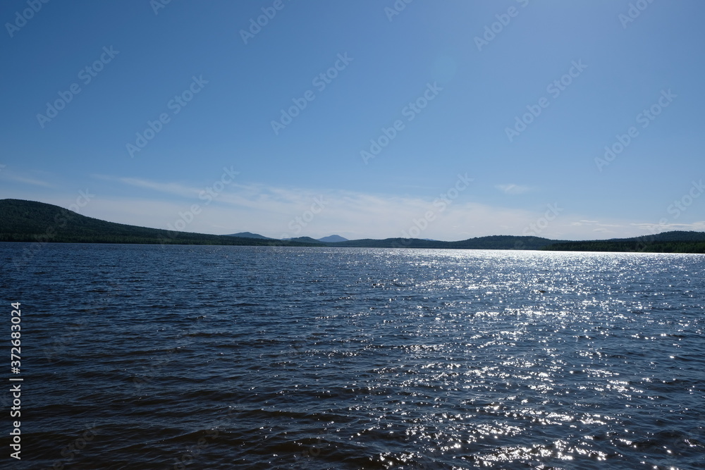 Lake Zyuratkul shines from the sun at noon