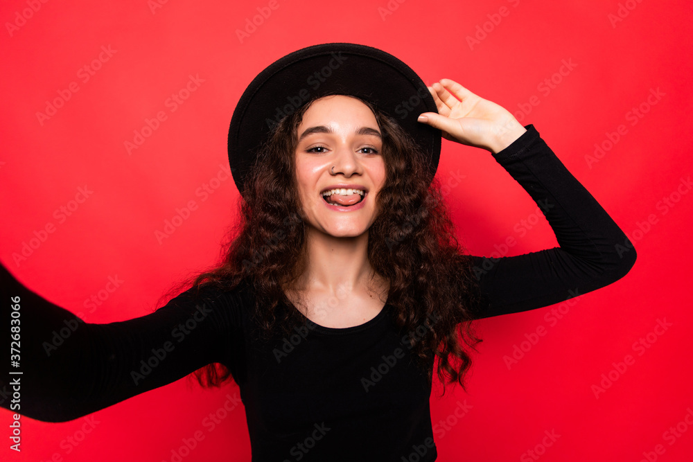 Young woman taking selfie isolated over red background Young woman taking selfie isolated over red background