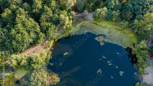 Drone photo over beautiful lake with green trees © Anton Tolmachov