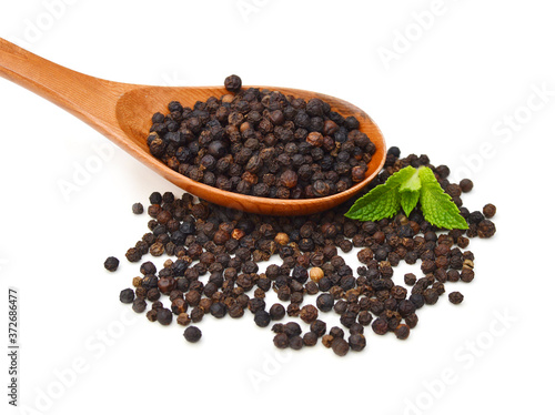 Black pepper was placed in wooden spoon on a white background and isolated