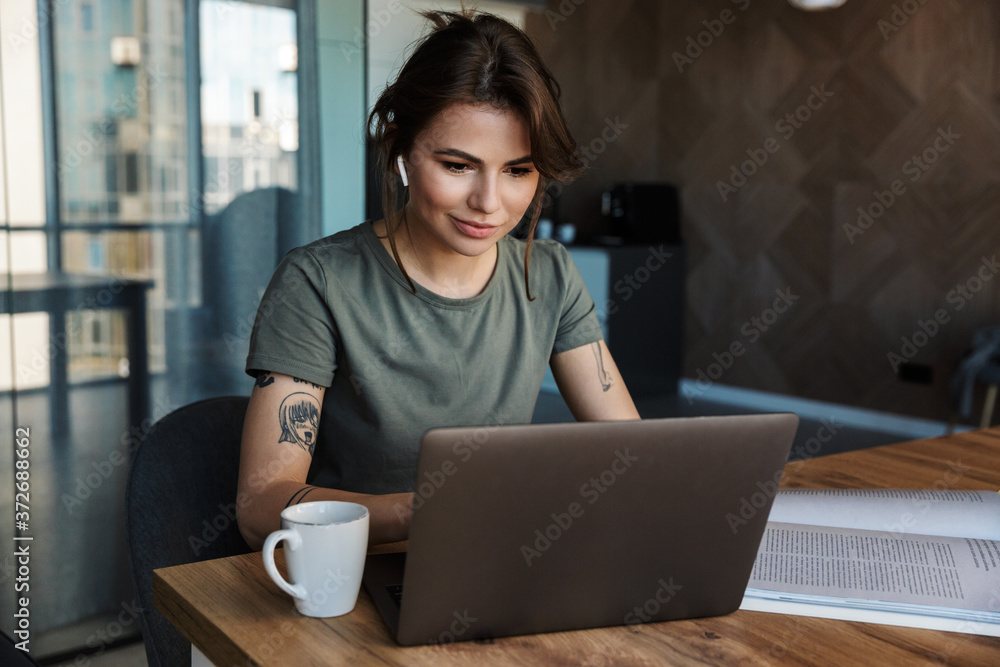 Attractive young woman working on laptop computer Attractive young woman working on laptop computer