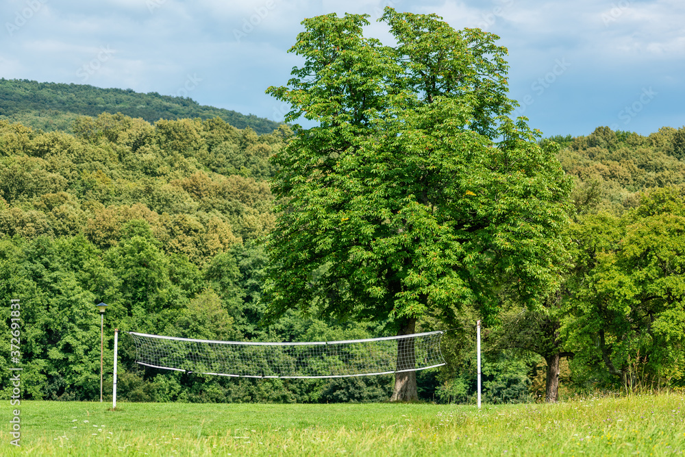 Volleyball net in the garden. Volleyball court in the woods Volleyball net in the garden. Volleyball court in the woods