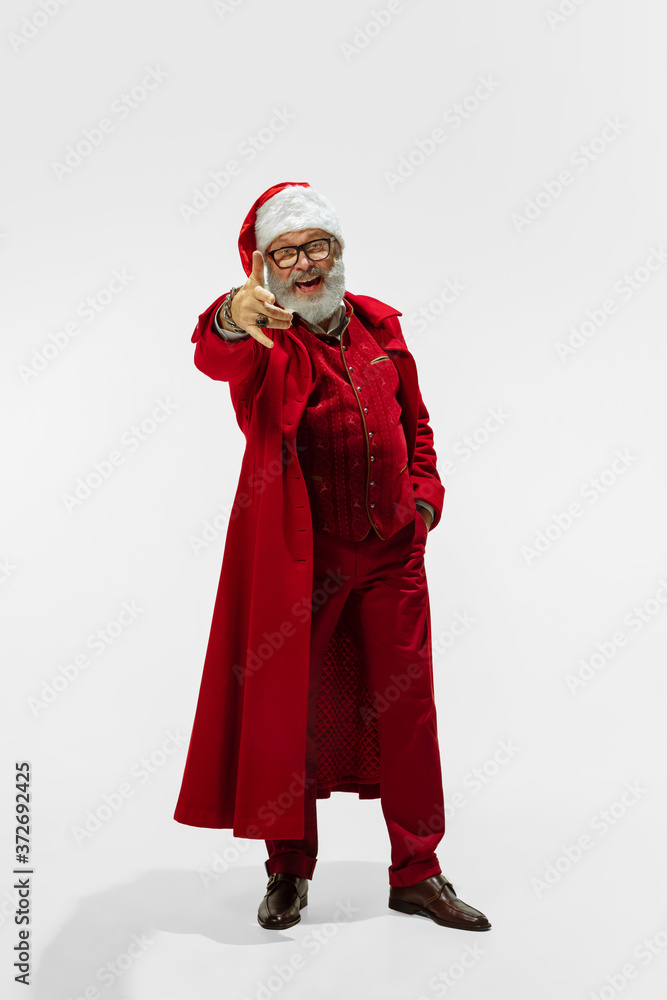 Choosing you. Modern stylish Santa Claus in red fashionable suit isolated on white background. Looks like a rockstar. New Year and Christmas eve, celebration, holidays, winter's mood, fashion.