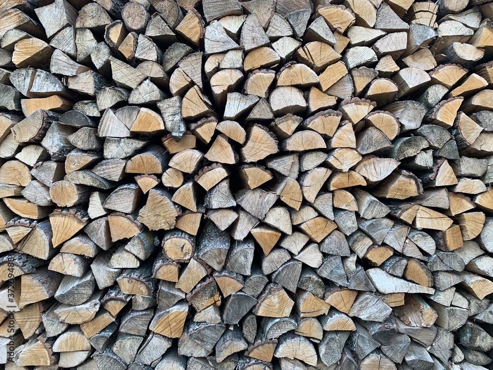 For the winter, ready-made chopped dry firewood. Background from logs, birch, pine and oak. A wall of chopped wood, ready to be burned in an oven. For the winter, ready-made chopped dry firewood. Background from logs, birch, pine and oak. A wall of chopped wood, ready to be burned in an oven.