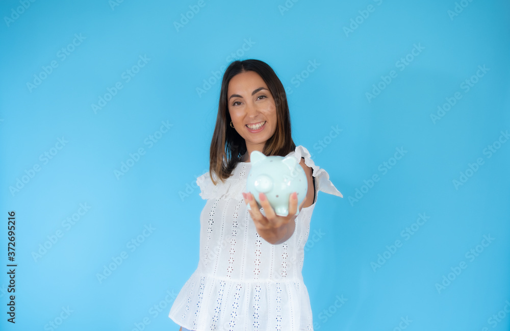 Woman in white shirt with a piggy bank smiling Woman in white shirt with a piggy bank smiling