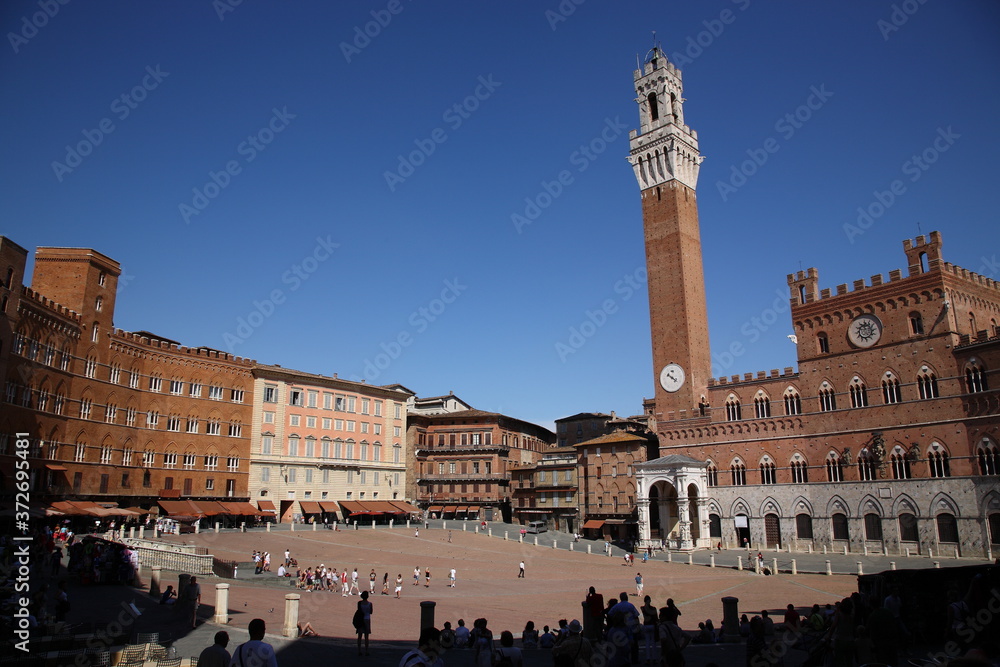 View of Mangia Tower at historic town square Piazza del Campo in  Siena, Tuscany, Italy