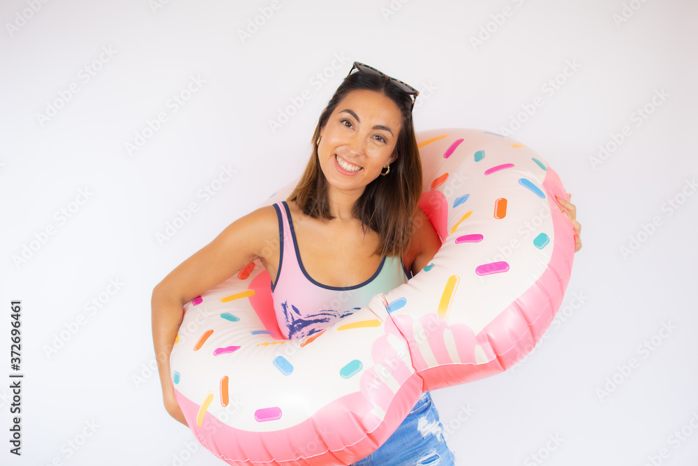 Pretty woman in swimsuit with a colorful float smiling