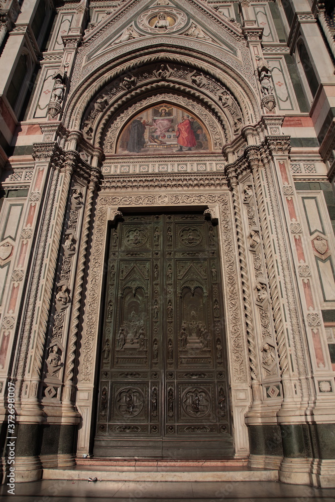 View of the Sculpture and painting on the door of Florence Duomo in Florence Italy