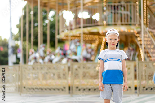 a cheerful child a boy of 5-6 years old walks in an amusement Park. Children lifestyle