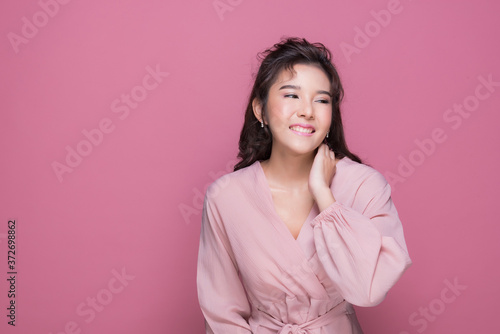 Portrait beautiful young woman in the studio on pink background 